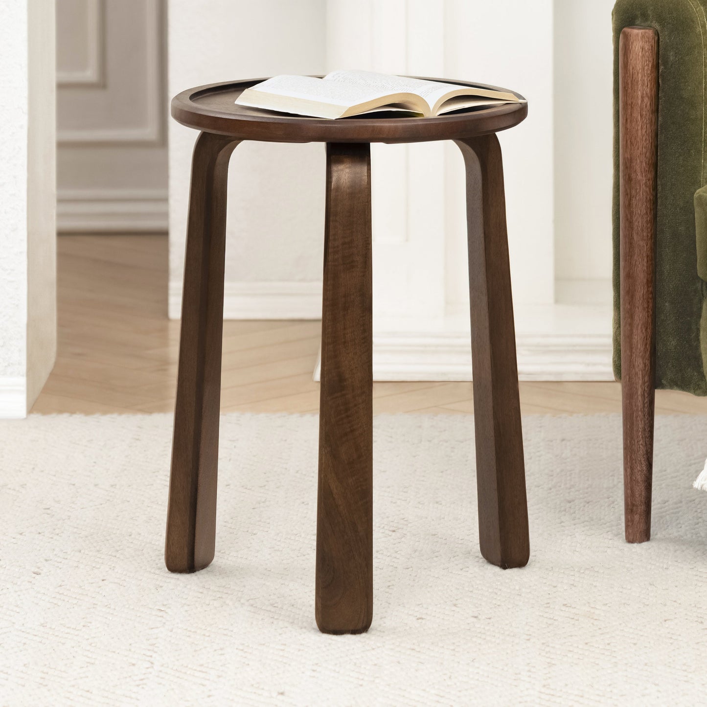 Wooden side table with an open book on a light-colored floor.