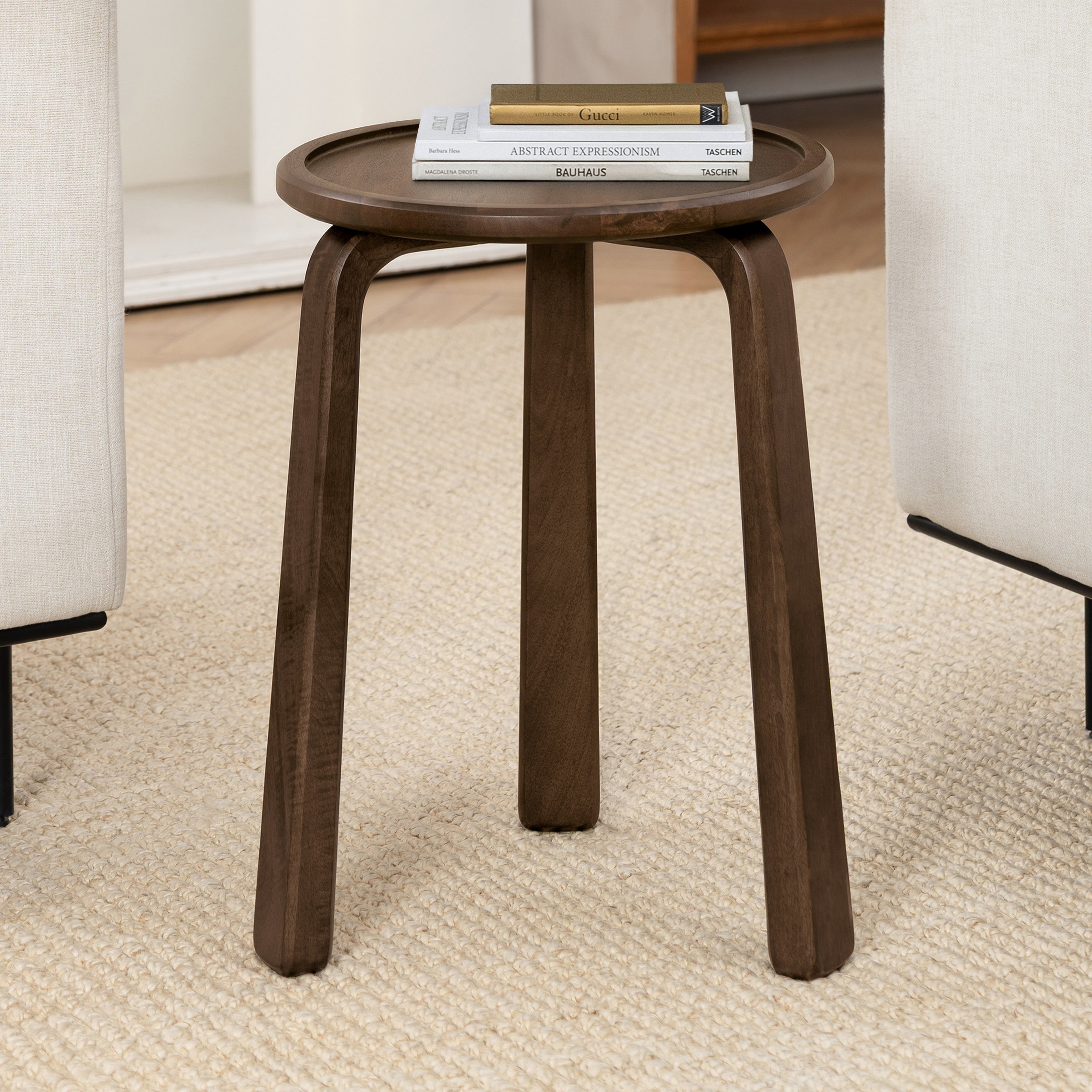 Wooden side table with books on a carpeted floor